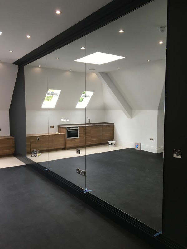 Frameless glass partition in loft conversion by Grove Park glaziers